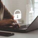 Frau tippt auf einem Laptop, während ein digitales Sicherheitssymbol mit Passwortschutz angezeigt wird – ideal für sichere Zugriffsverwaltung mit Keycloak.