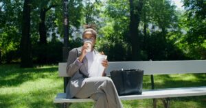 Businessfrau trinkt Kaffee auf Parkbank | Immobilienbewertung Stuttgart